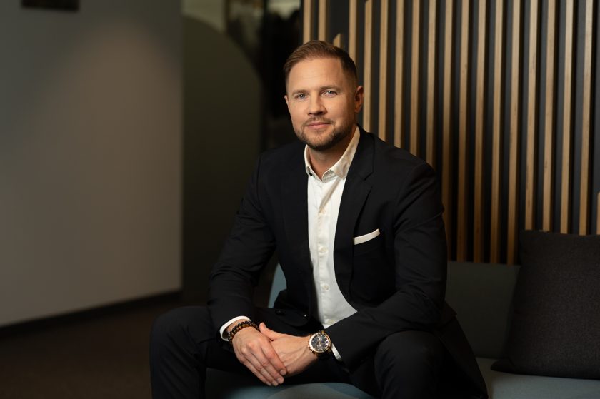 Allan Valm, AI Tech Partner and Business Area Leader at Helmes, seated in a dark suit and white shirt